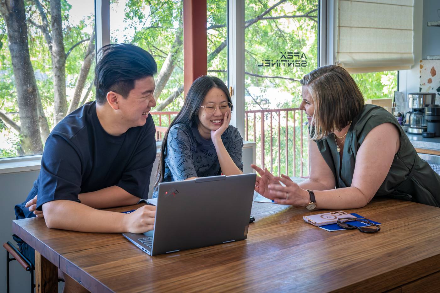 Three Eolas team members working together over a laptop